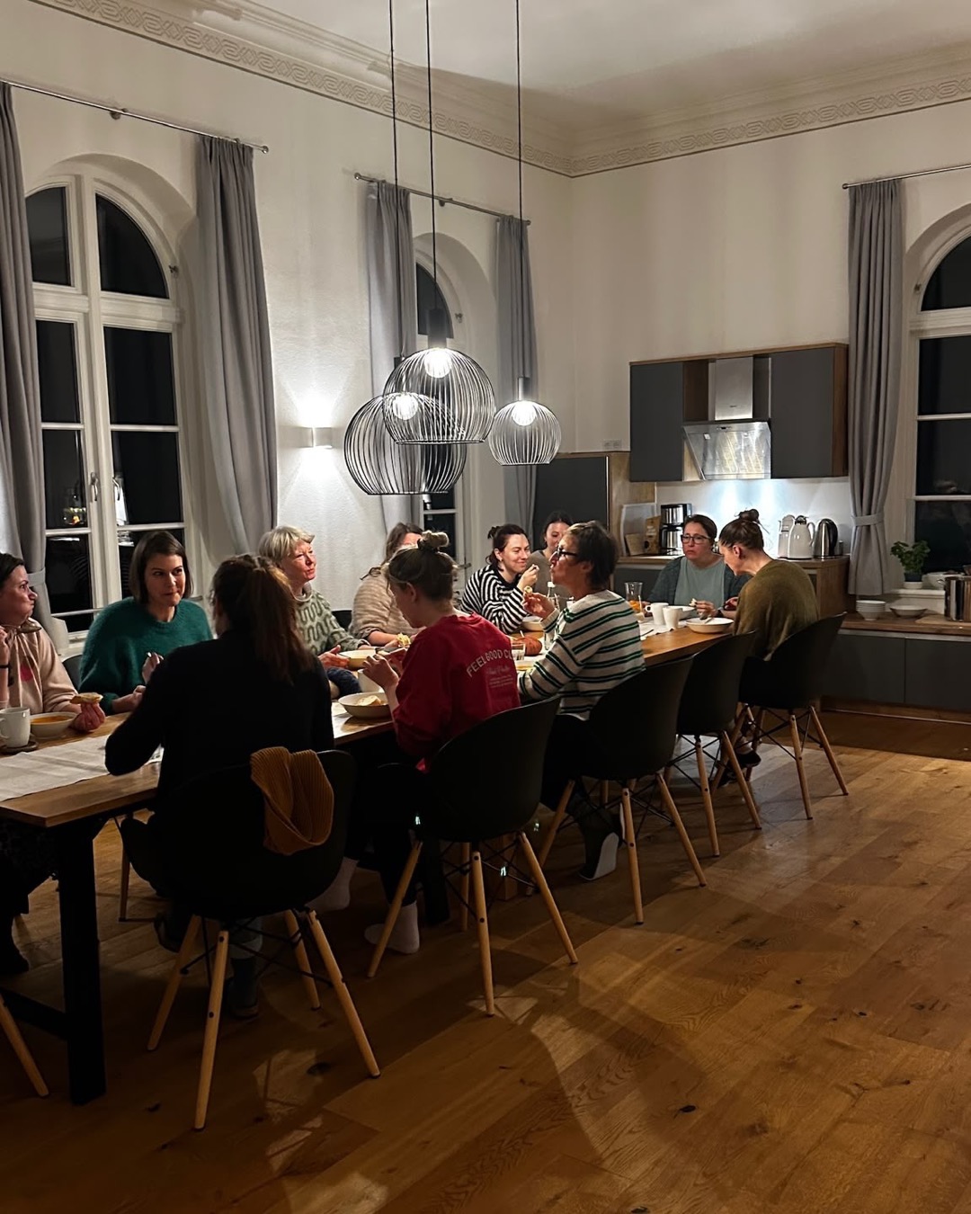 Frauenrunde beim Abendessen am langen Tisch im Gutshaus