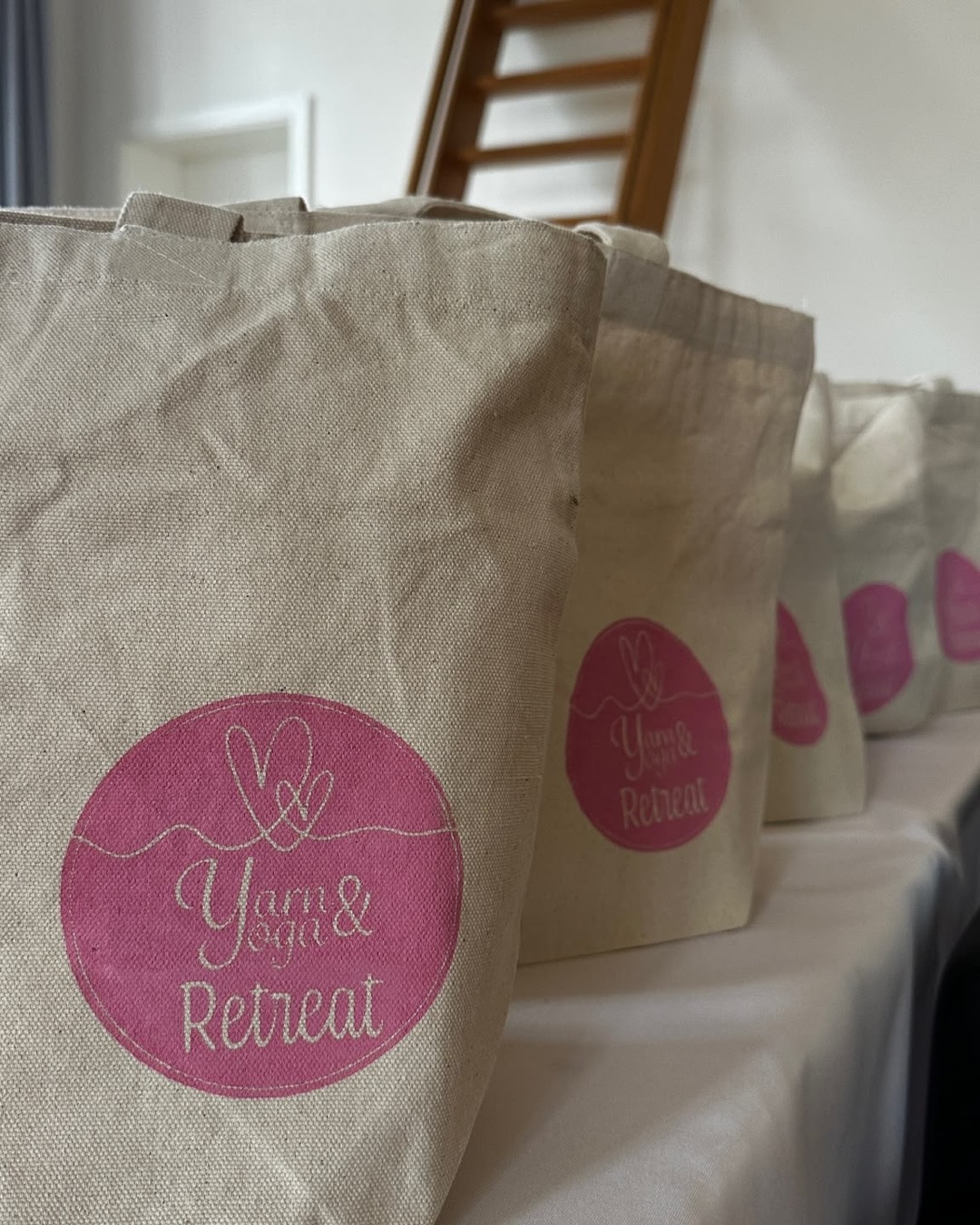 Stofftaschen mit dem Yarn & Yoga Retreat Logo in einer Reihe